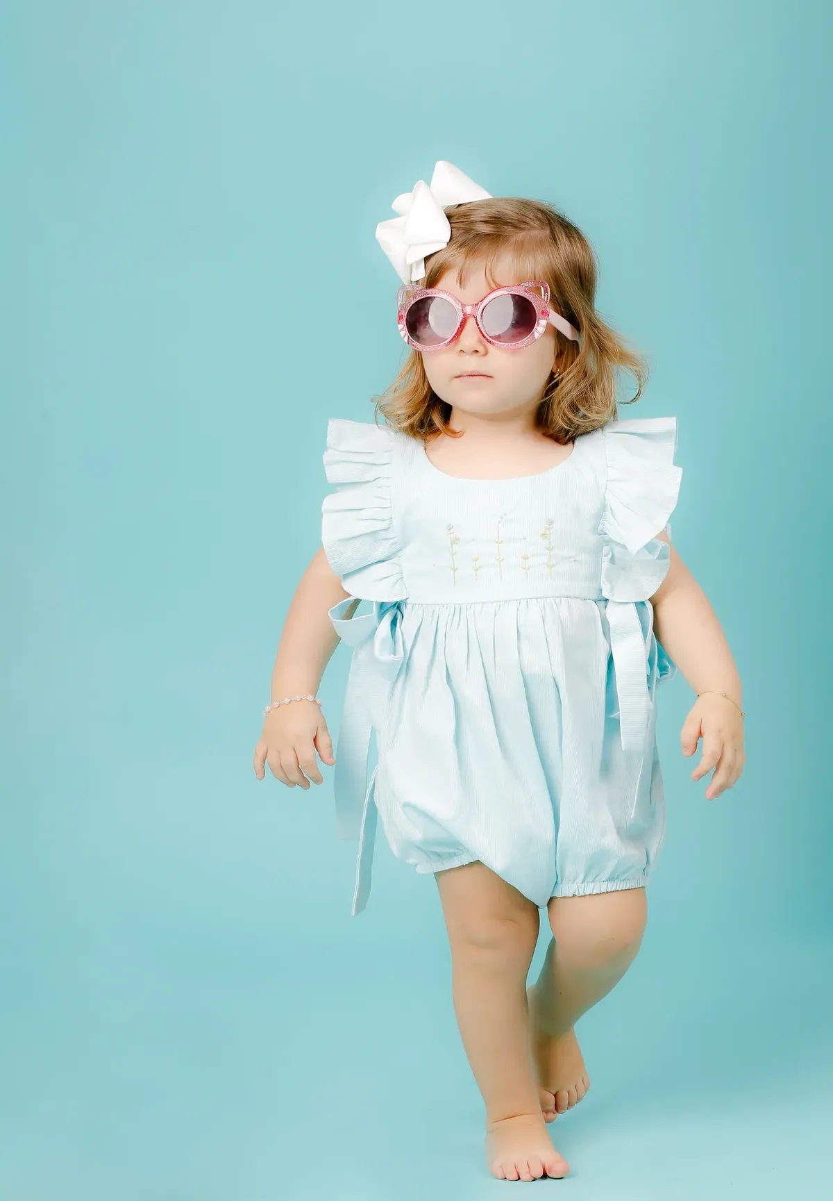Menina de óculos rosa em fundo azul